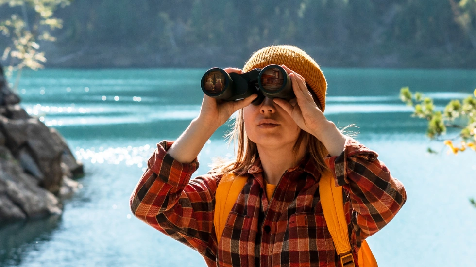Frau mit Fernglas in der Natur